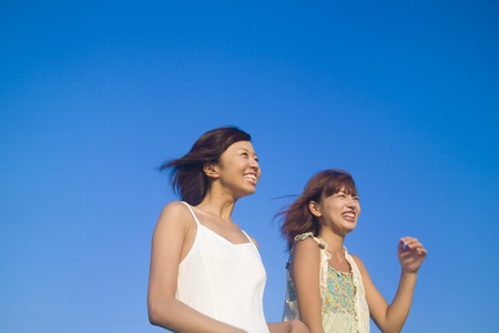 2 women walking while talkingの写真素材