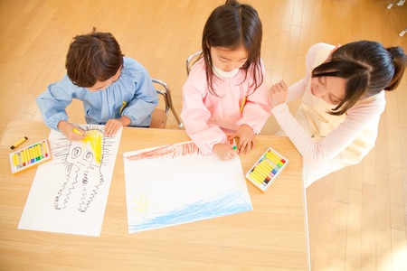 Kindergarten teachers to watch and kindergarten children to enjoy paintingの写真素材