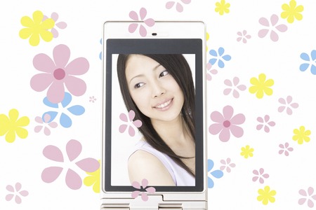 Women's smiles reflected on the mobile screenの写真素材