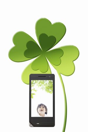 Four Leaf Clover and girl moves to a mobile screenの写真素材