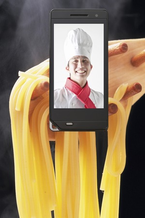 Chef moves to pasta and mobile screenの写真素材