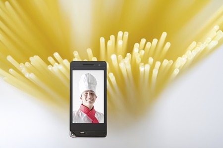 Chef moves to pasta and mobile screenの写真素材