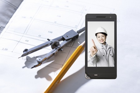Person wearing work clothes, which goes to the drawings and the portable screenの写真素材