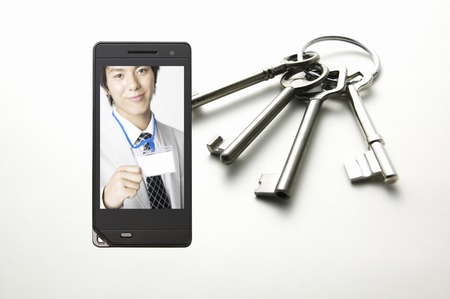 Businessman to show employee ID card, which moves to the mobile screenの写真素材
