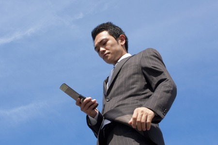Businessman to the e-mail on a mobile phoneの写真素材