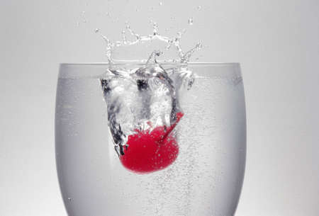 Splash scattered with cherry that has been thrown into a glassの写真素材