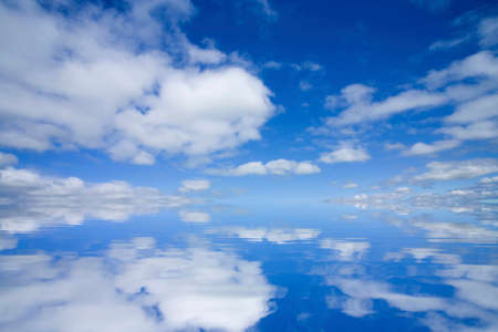 White clouds and blue sky reflected on the water surfaceの写真素材