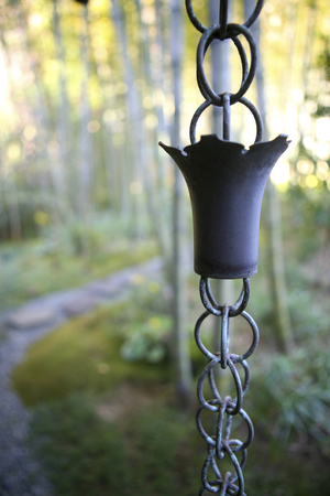 Chain of ornamental cups hanging from a gutterの写真素材