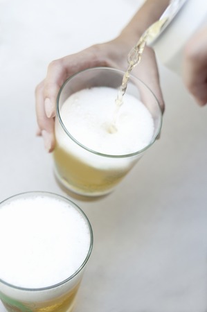 Hand pouring beerの写真素材