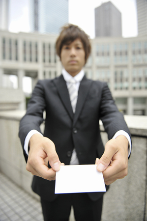Business card hold out businessmanの写真素材