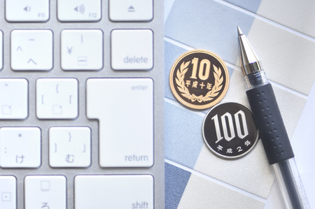 Keyboard and coin and ballpoint pen