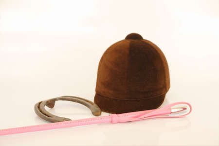 Horseshoes and jockey helmet and gloves and stick horse