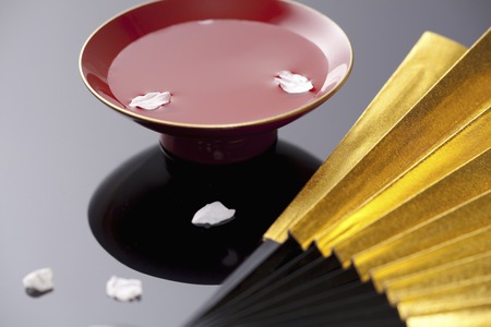 Floating liquor and fan of cherry petalsの写真素材