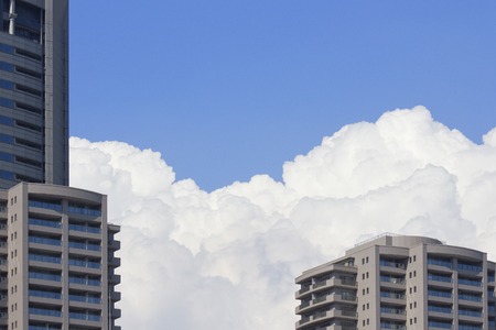High rise apartment buildings and blue sky and white cloudsの写真素材