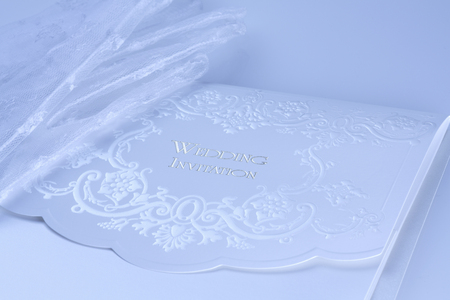Lace wedding invitations with bride's white glovesの写真素材
