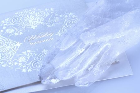 Lace wedding invitations with bride's white glovesの写真素材