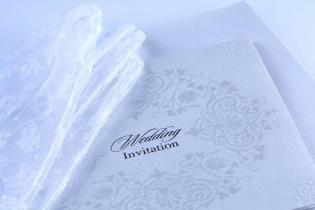 Lace wedding invitations with bride's white glovesの写真素材