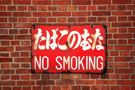 Non smoking sign pasted on the wall of the brickの写真素材