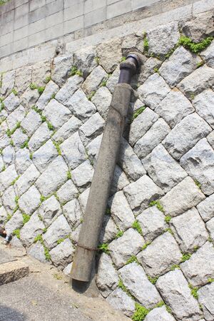 Drainage clay pipe of the rainwater along the private house of Ishigakiの写真素材