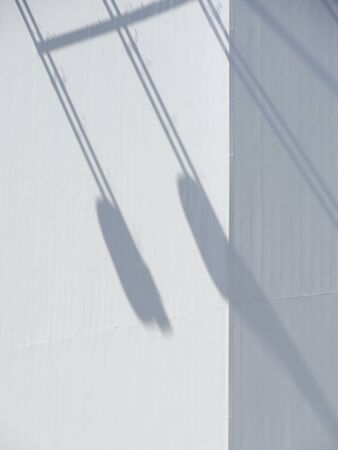 The shadow of the street lights reflected on the wall of the buildingの写真素材