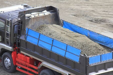 Dump truck carrying sand at construction siteの写真素材