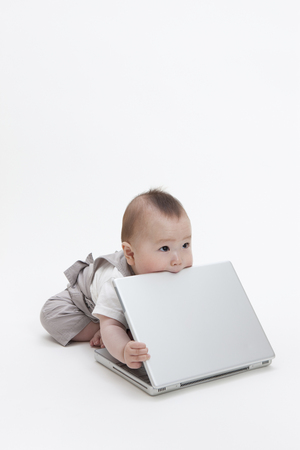 Baby gnaw a laptopの写真素材