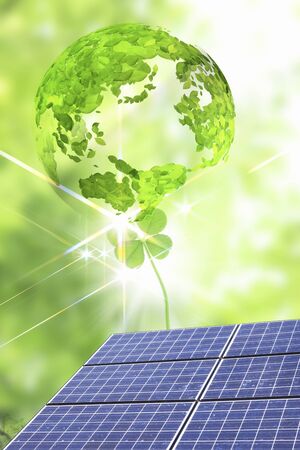 Globe of solar panels and fresh green leaves and leavesの写真素材