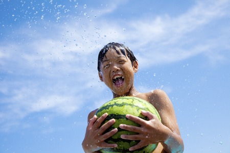 Summer of children facing a watermelonの写真素材