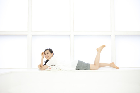 Women who lie flat on the windowsillの写真素材