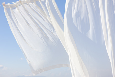 Blue sky and white curtainsの写真素材