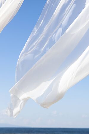 Blue sky and white curtainsの写真素材