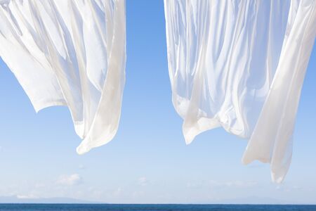 Blue sky and white curtainsの写真素材