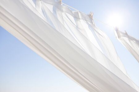 Blue sky and white curtainsの写真素材