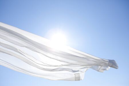 Blue sky and white curtainsの写真素材