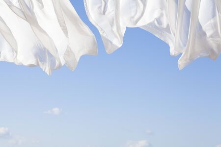 Blue sky and white curtainsの写真素材