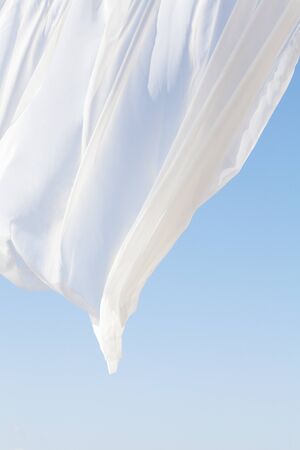 Blue sky and white curtainsの写真素材