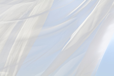 Blue sky and white curtainsの写真素材