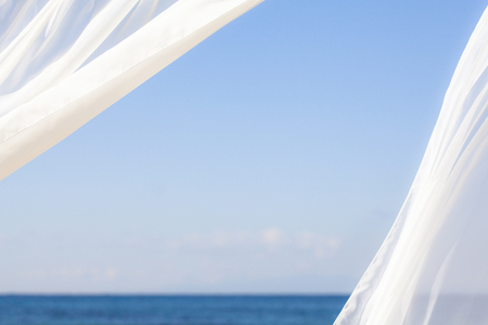 Blue sky and white curtainsの写真素材