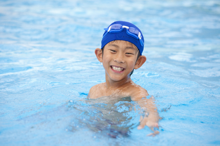 Elementary school students playing by the pool boyの写真素材