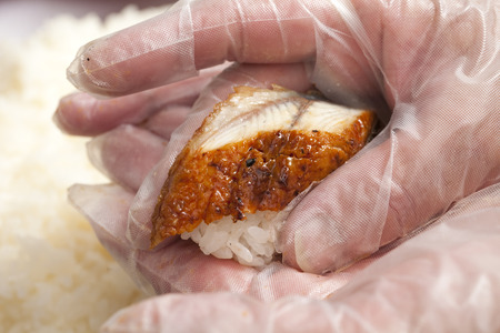 Sushi to grips with cooking glovesの写真素材