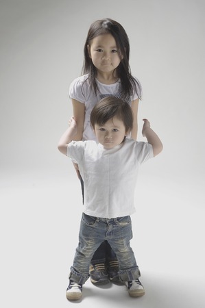 Stacked vertically and 6-year-old sister, stand 2 years old childrenの写真素材