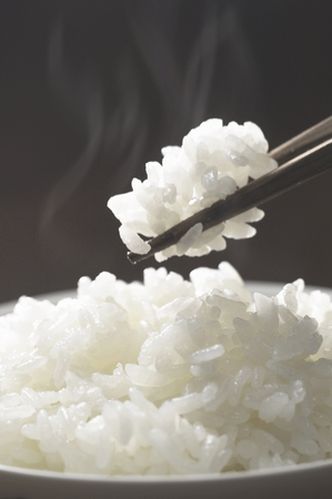We receive with chopsticks rice to increase the steam of freshly cookedの写真素材