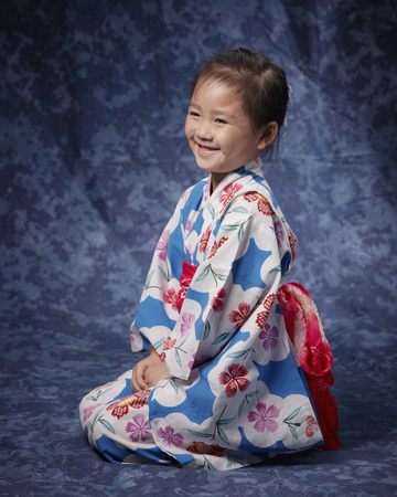 Yukata girl laugh by sitting straight sidewaysの写真素材