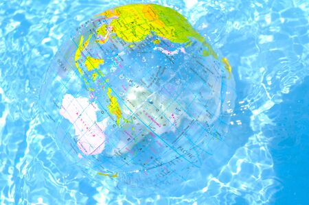Beach ballshaped the Earth floats on the surface of the water.の写真素材