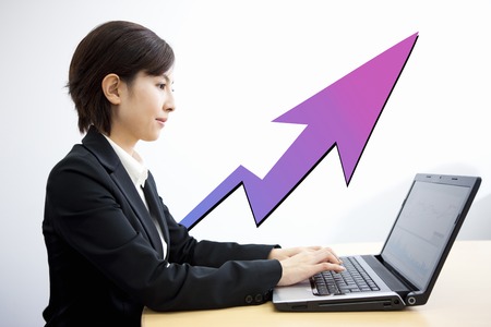 Woman to check the stock price on a laptopの写真素材