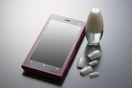 Smart phone with nail polishの写真素材
