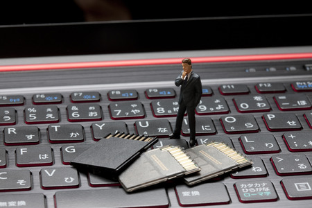 Miniature businessmen to think by looking at the memory card