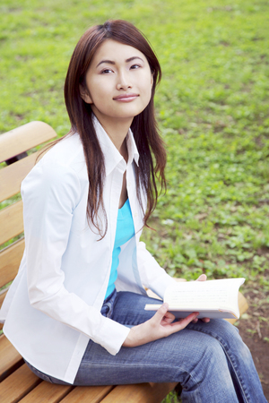 Woman reading on a benchの写真素材