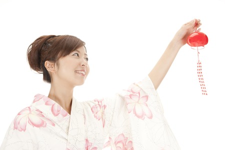 Yukata woman to attempt to install a wind chimeの写真素材
