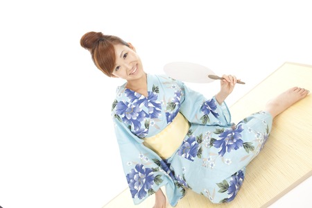 Yukata women flexing in the fan sittingの写真素材